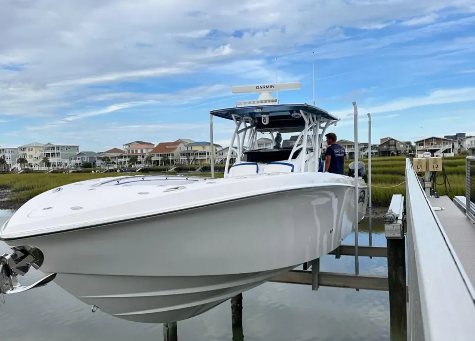 White center console on a boat lift beside the dock