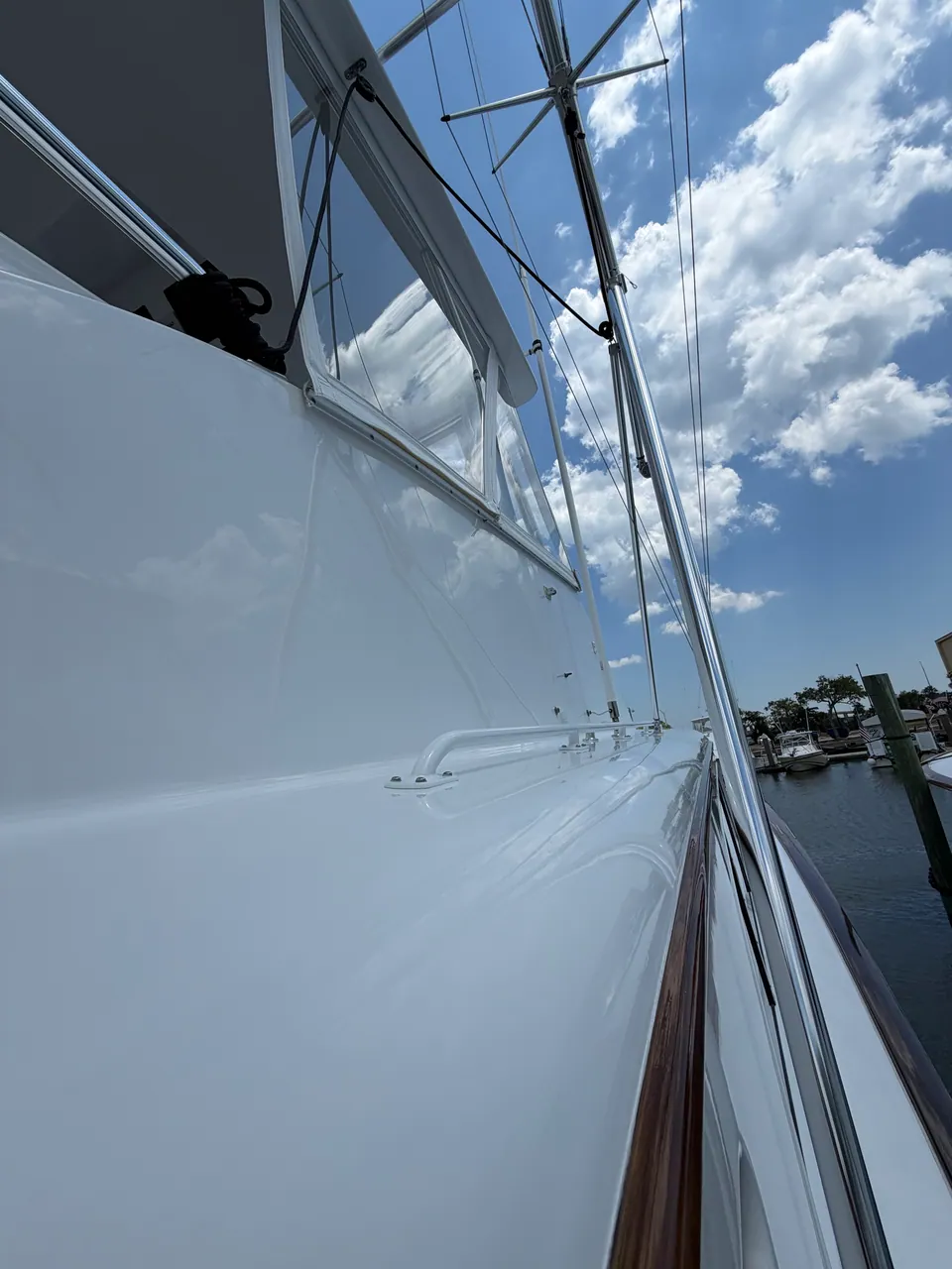 Sky and rigging reflected along the white topsides of a sportfishing boat
