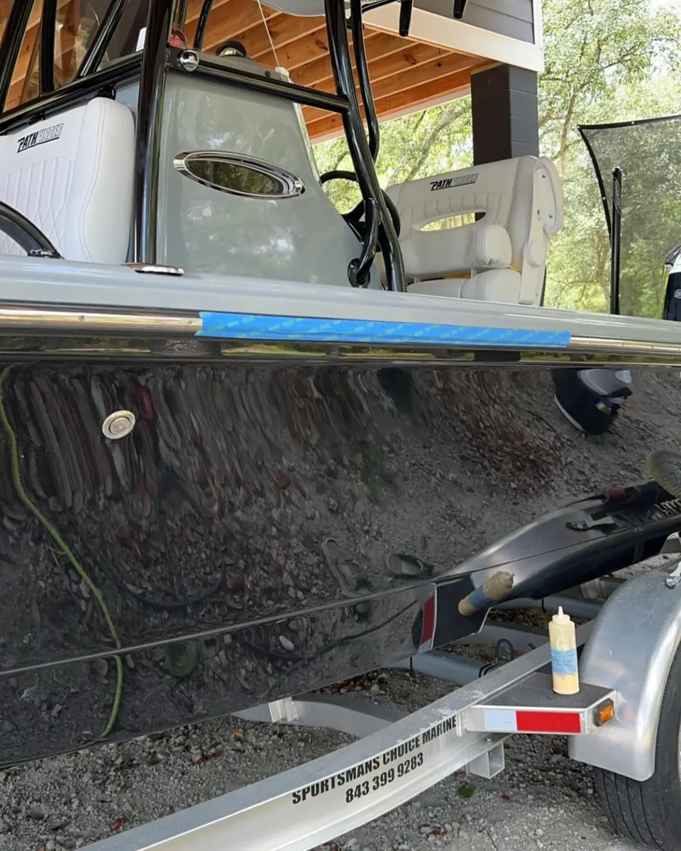 Dark hull with surface preparation marks under a covered workspace