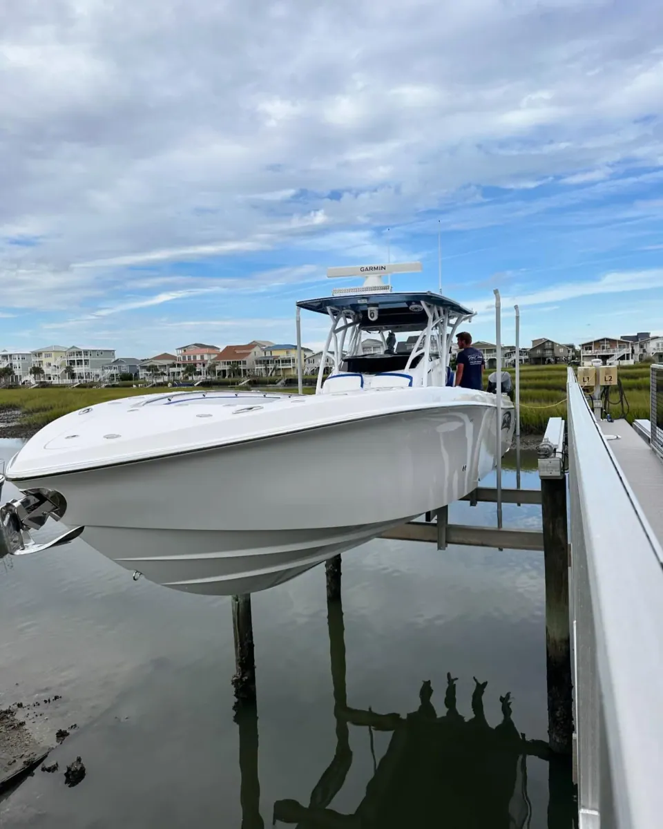 White center console on a boat lift under a blue sky