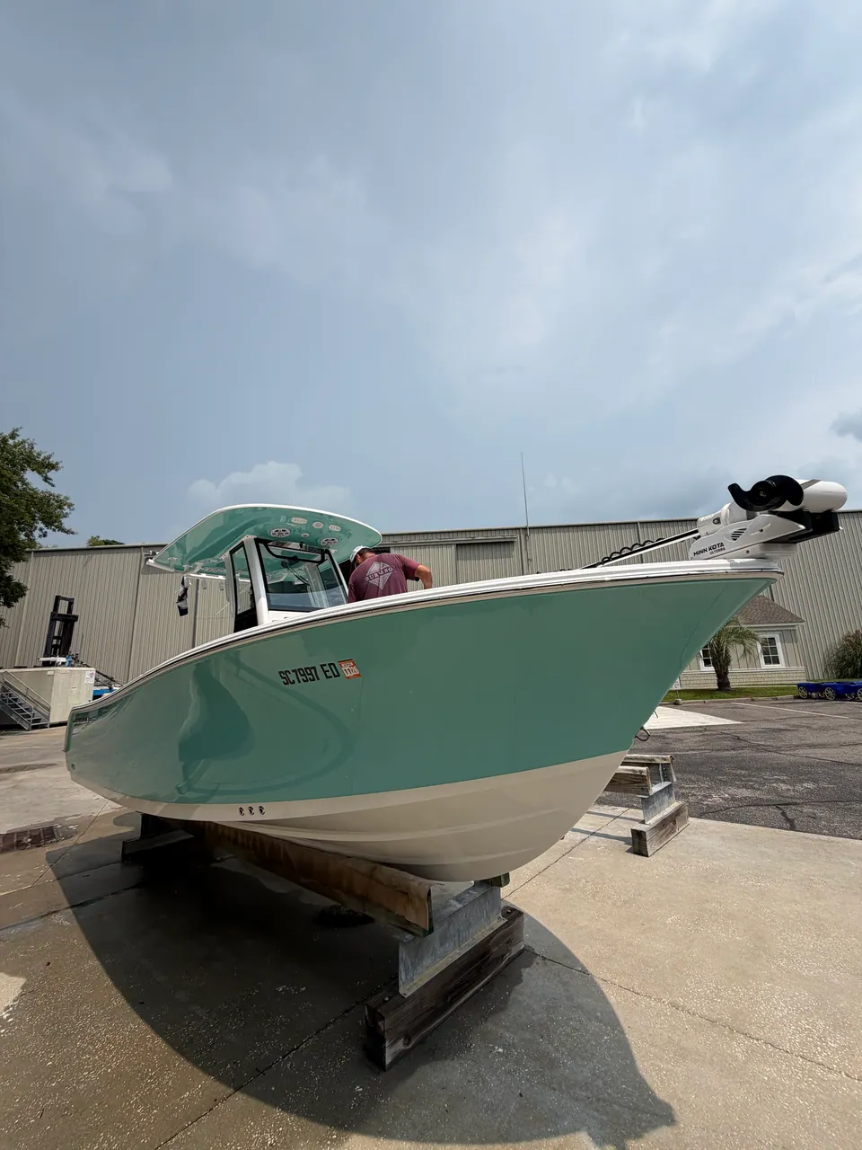 Seafoam-green center console on stands in a boatyard