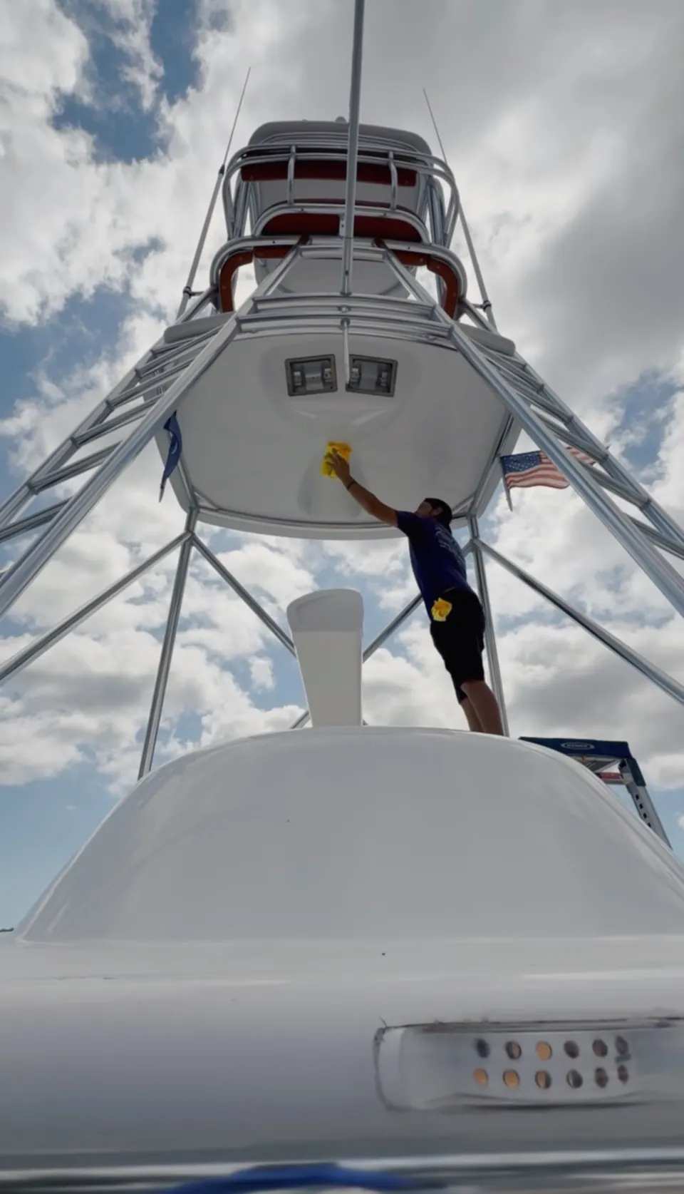 Looking up at a sportfishing tower while its underside is wiped down