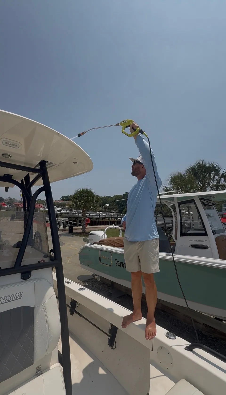 Cleaning a center console T-top with a pole brush from the gunwale